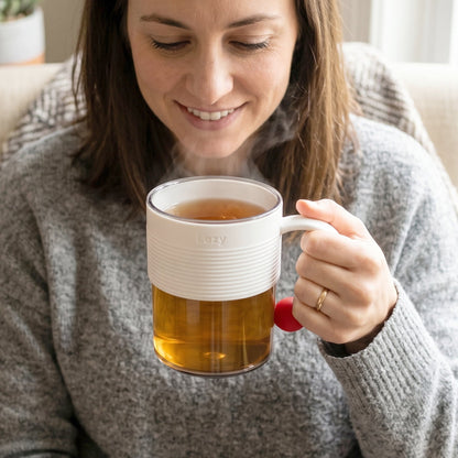 Transparent plastic mug being used for drinking a hot beverage.