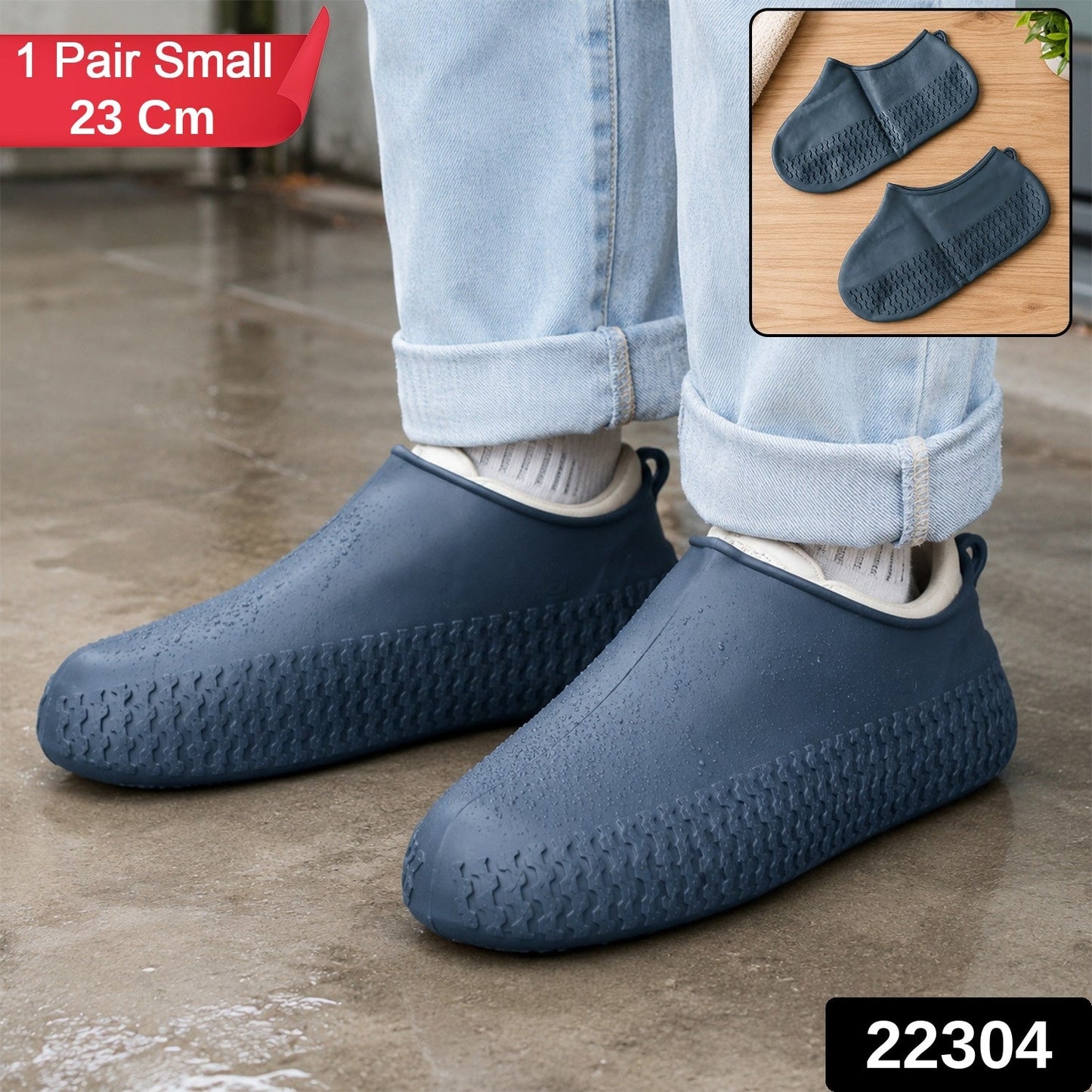A person wears navy blue silicone shoe covers over their shoes, standing on a wet surface, with product details in the