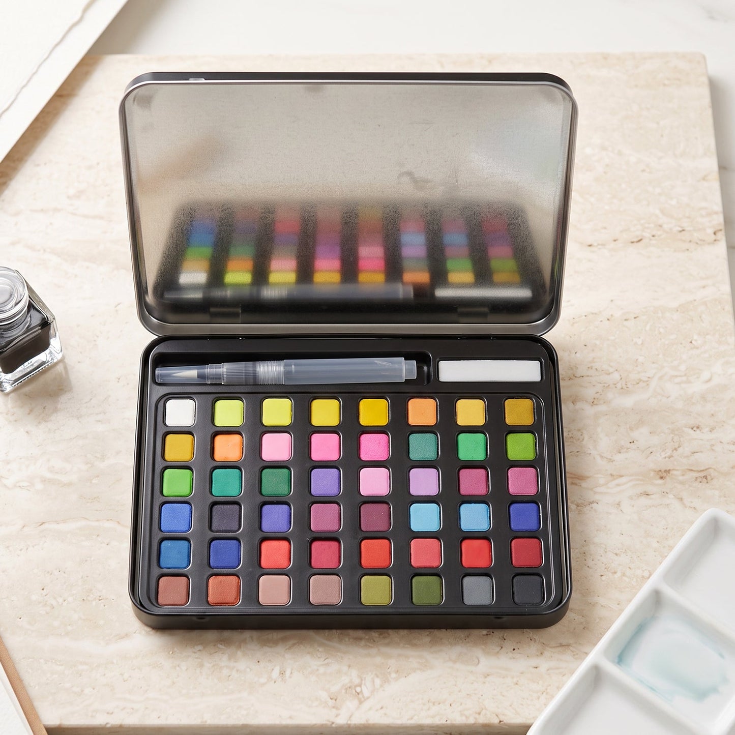 Solid watercolor paint palette in metal storage box
