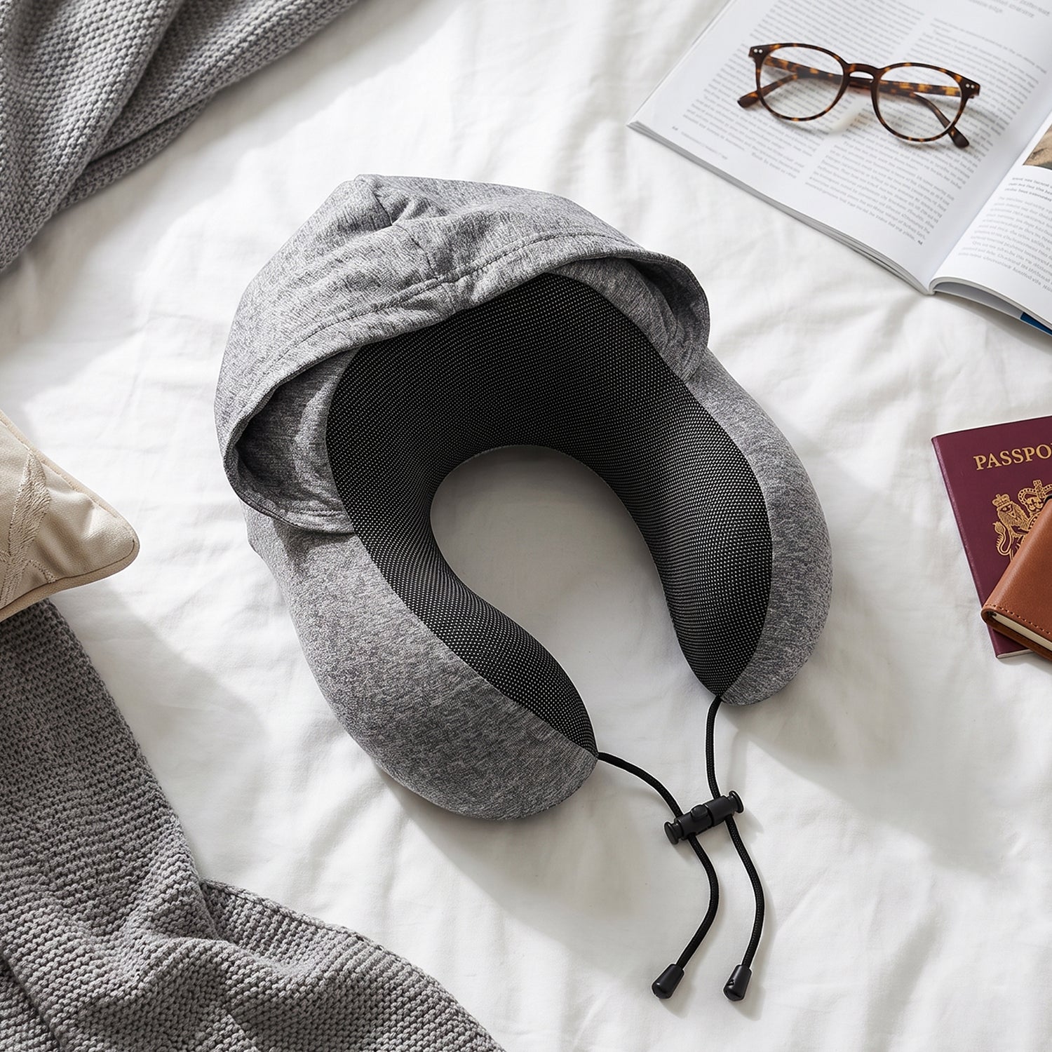 Grey travel pillow with hood to block light while sleeping