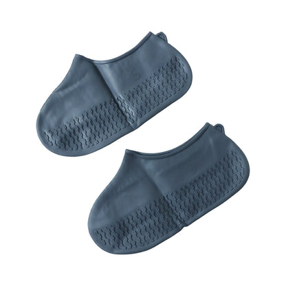 Two dark grey silicone shoe covers are displayed side by side on a white background, showing their textured soles.